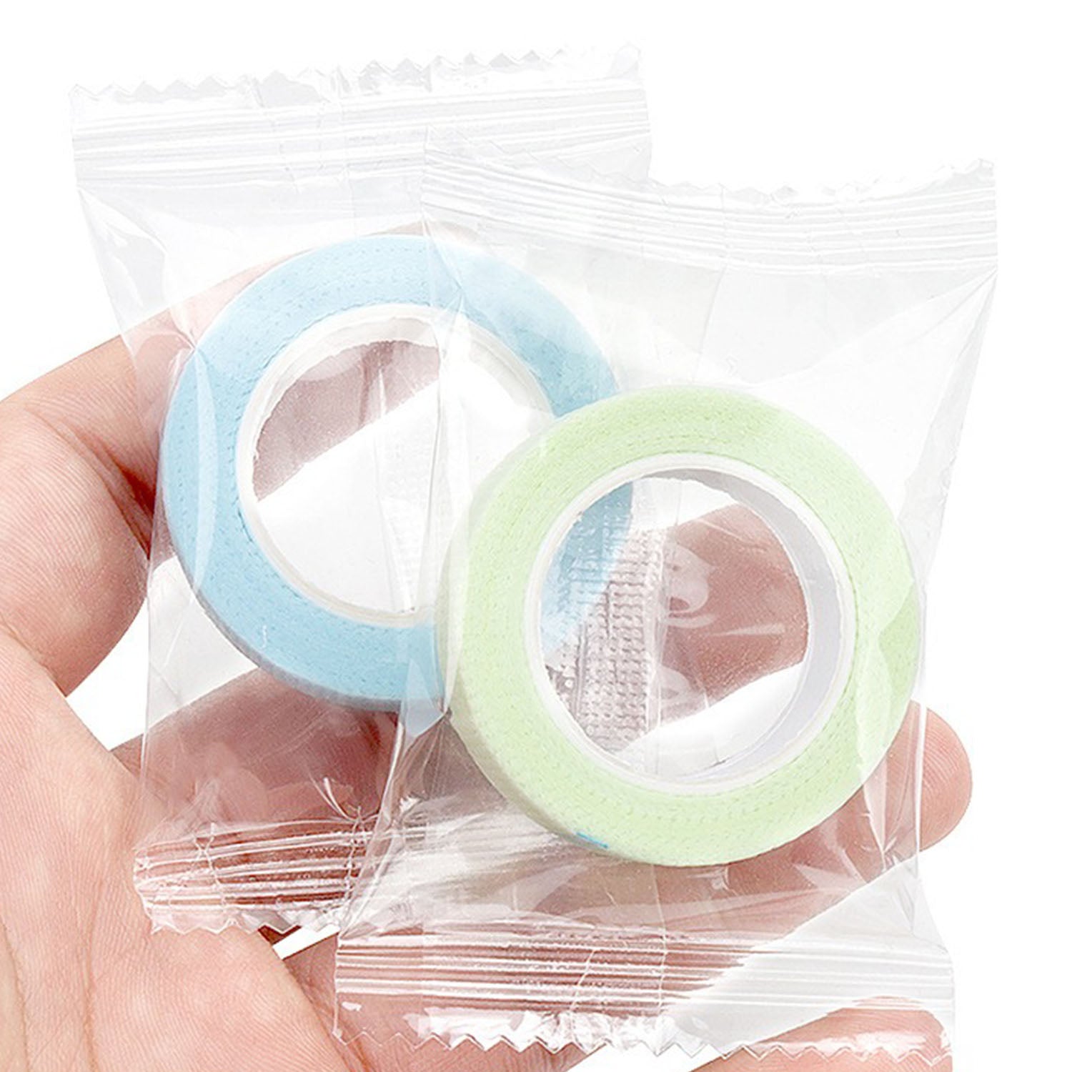 Individually wrapped blue and green YSEN’S micropore lash tape rolls